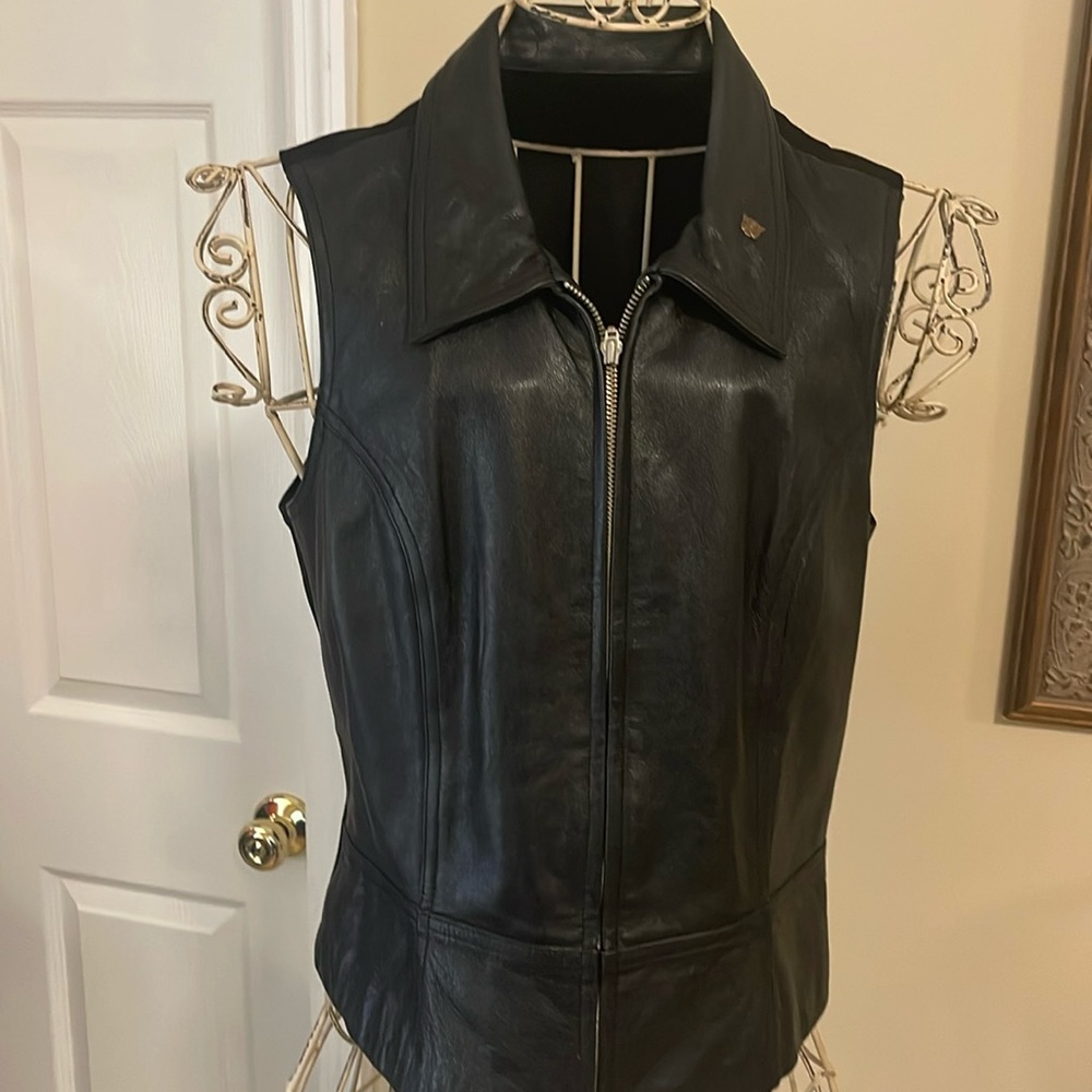 Woman’s sized large( snug fit) black leather vest. Leather front, fabric back.